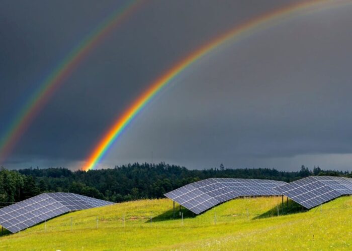 Solar PV field with rainbows in the background